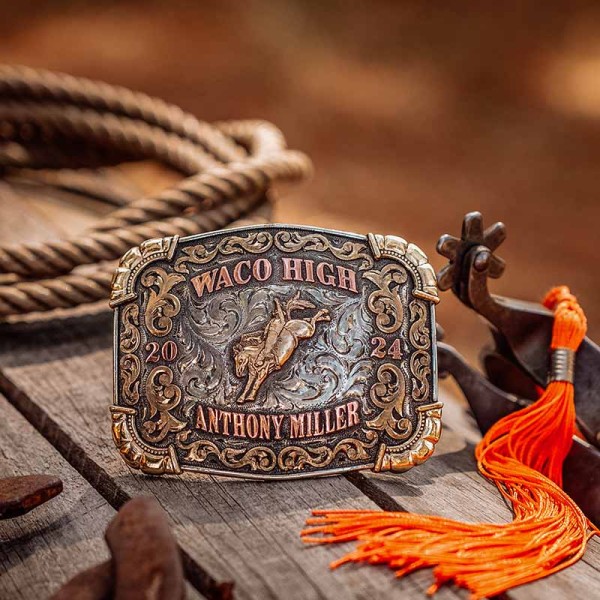 A custom rodeo belt buckle for Waco High School with personalized name featuring a golden bronze bronc rider cowboy figure 